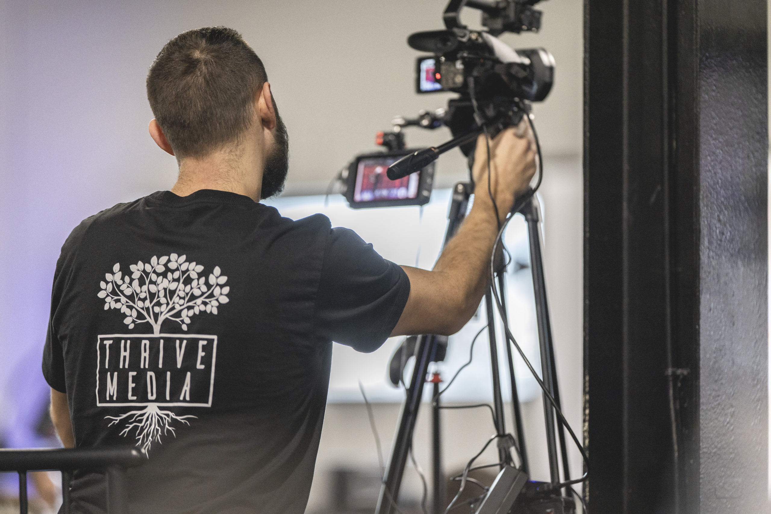 Professional portrait of Sean FitzGibbons holding a Sony camera rig on a gimbal. Used on Thrive Media's About page to showcase the founder